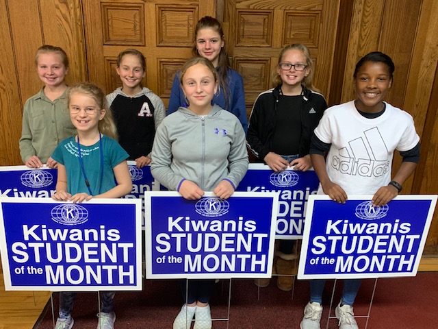 the selected students of the month are posed with their yard signs declaring they are a Kiwanis Student of the Month
